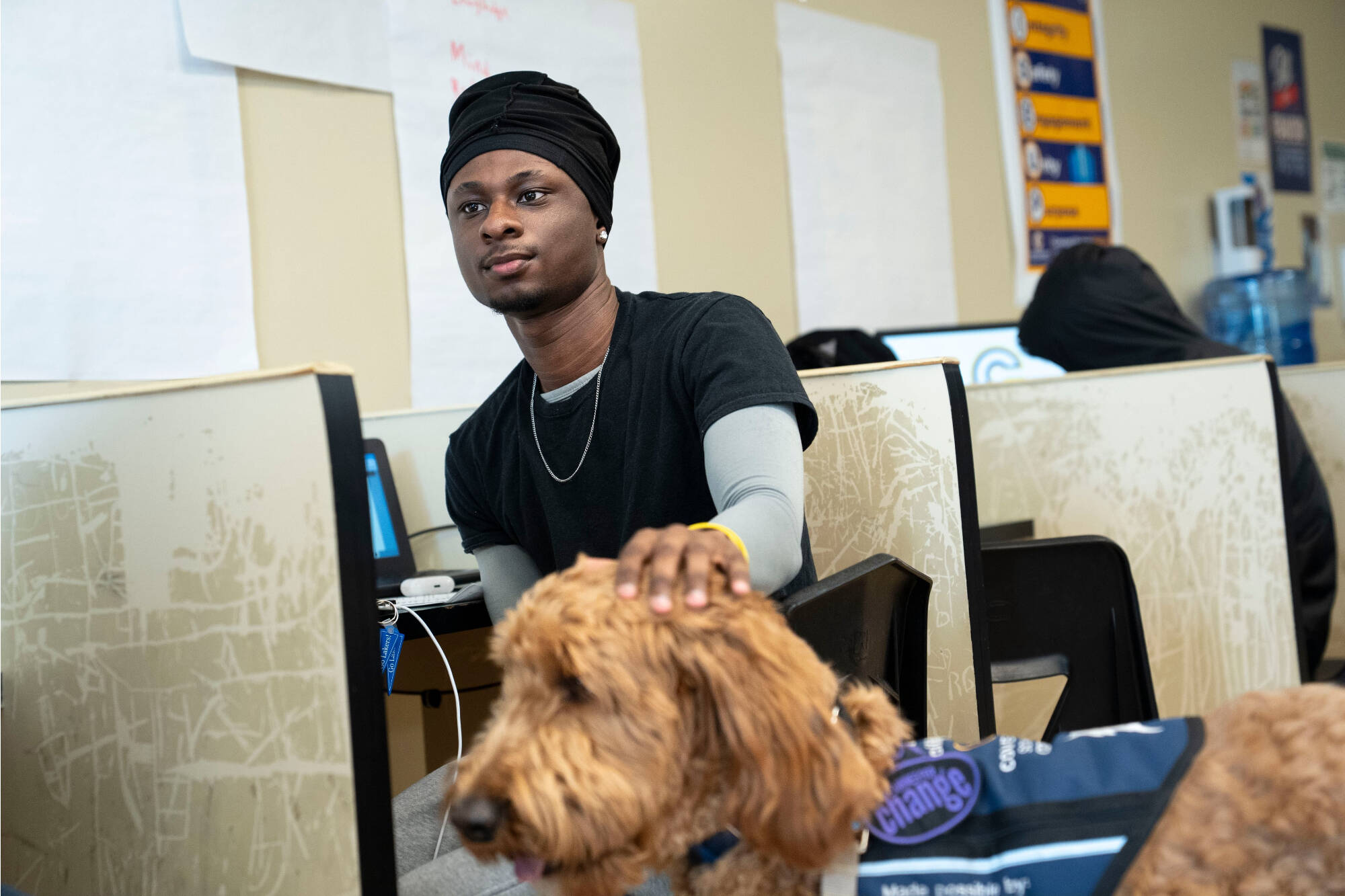 male student petting head of Beau the dog